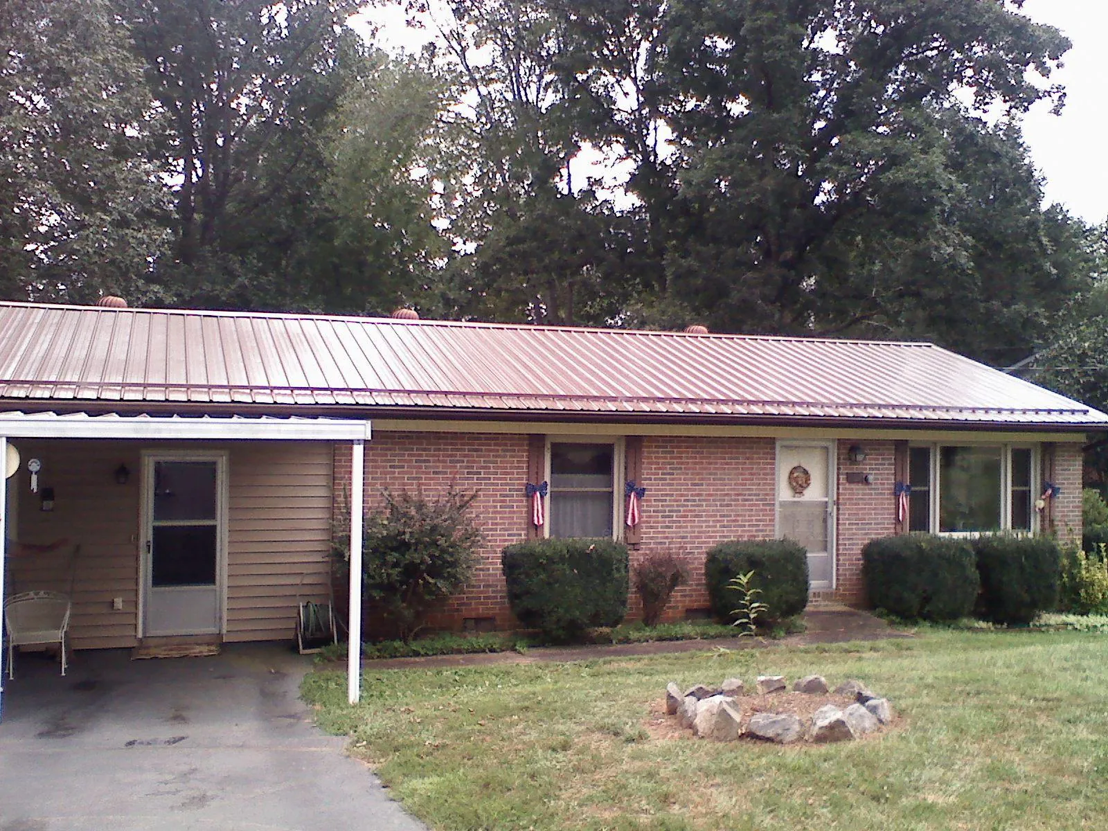 Bronze metal roof and carport on a brick ranch home — Roof Repair work by our crew in Oakland Gardens