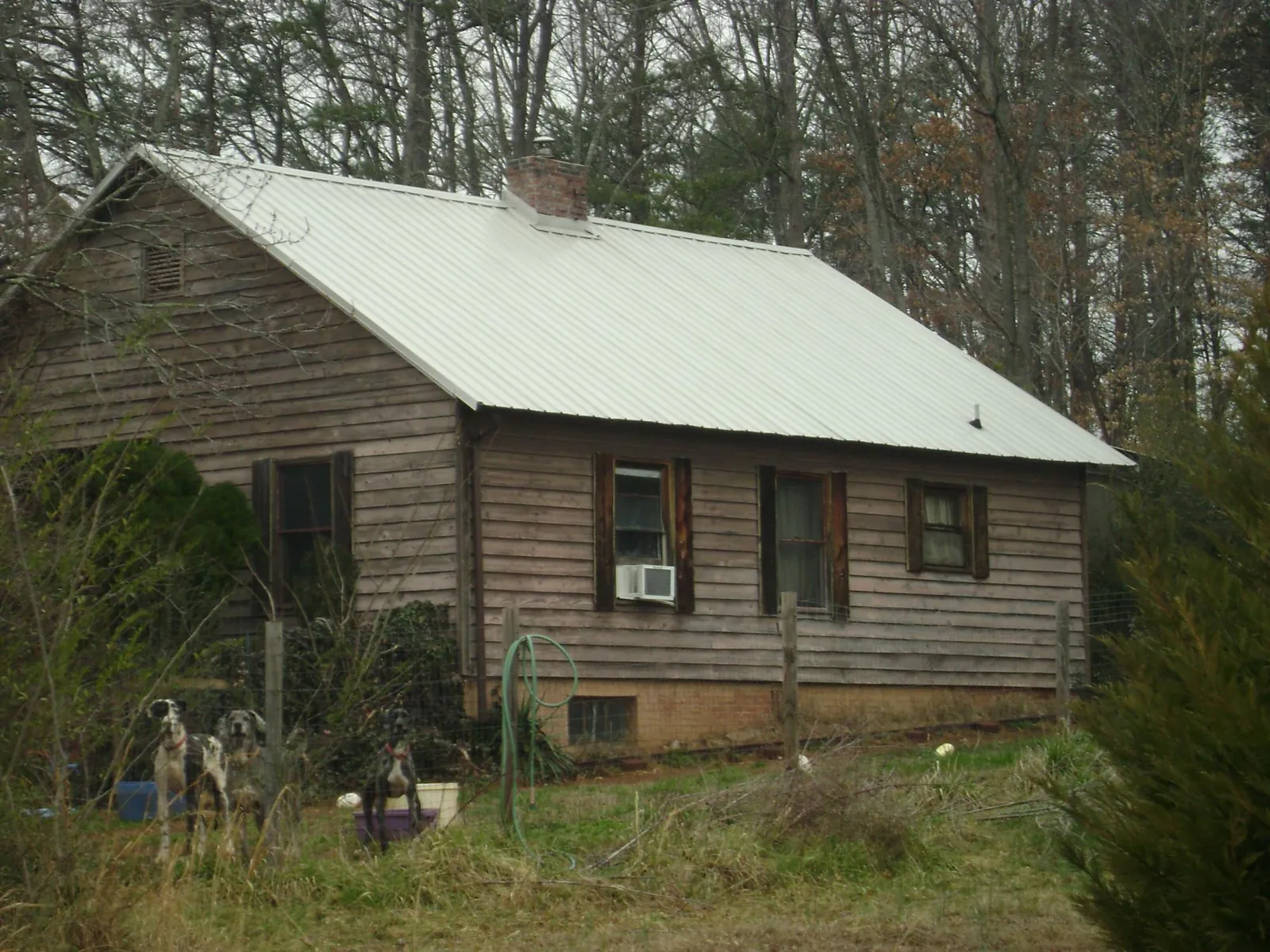 White metal roof on an old wood sided farmhouse, from a Metal Roof Installation job in Oakland Gardens